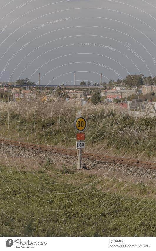 Railroad with traffic signs and refinery and apartments in the background Refinery by rail Train Transport Traffic infrastructure Means of transport