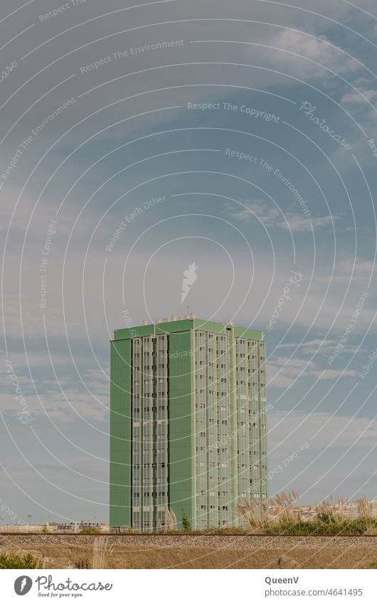 High-rise building with green facade and rails in the foreground Architecture Town Train Railroad system Train travel Traffic infrastructure Public transit