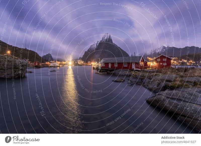 Amazing view of snowy mountains and village located at bottom range settlement house sunset highland landscape picturesque lofoten island norway reine hill