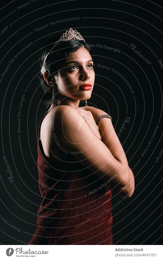 Charming sensual woman in tiara looking up against black background allure gorgeous dress elegant grace charming tender fashion portrait glamour chic flawless