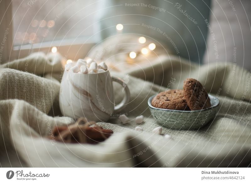 Cozy holiday season morning breakfast at home. Christmas cinnamon cookies with cup of cocoa with marshmallows. Cozy relaxing moments on windowsill at home with sweet dessert, enjoying life.