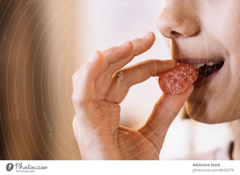 Person biting sweet marmalade against blurred background person bite tasty sugar delicious yummy food dessert eat show calorie appetizing joy confectionery