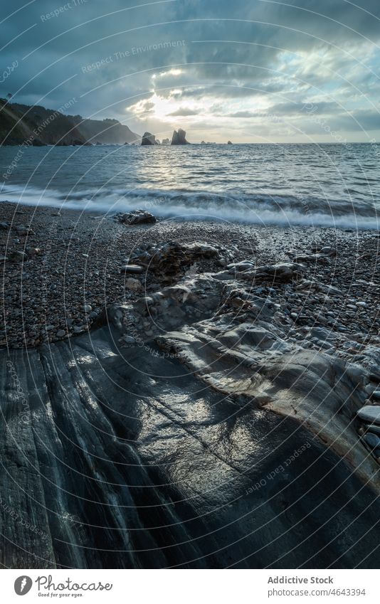 Playa del Silencio beach near sea water coast nature pebble stone shore mountain cloudy asturias spain rough rocky environment scenery seashore seaside