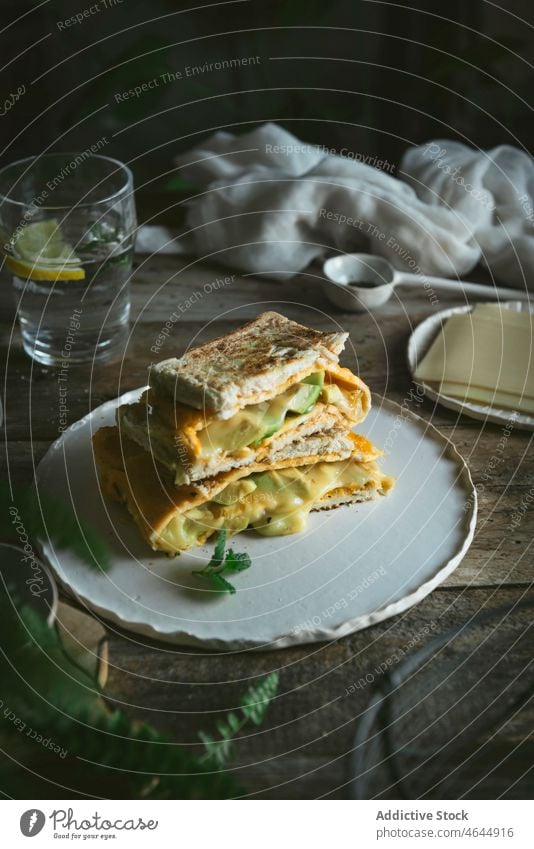 Avocado omelet sandwich served on ceramic plate delicious snack gourmet ingredient food bread avocado lunch healthy breakfast dinner toast vegetable cheese