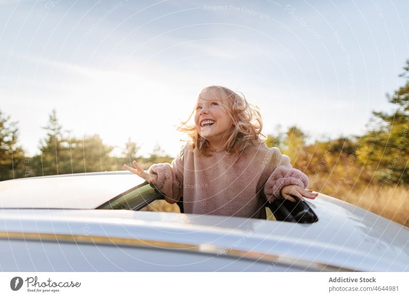 Cute girl in sunroof of car child road trip pastime passenger countryside automobile leisure commute vehicle journey transport adventure automotive open cute