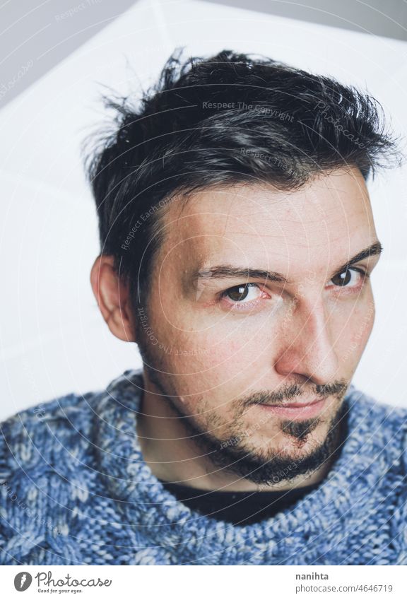 Portrait of a handsome young man against white background male portrait studio expression face mood moody guy eyes look close close up beard brunette black hair