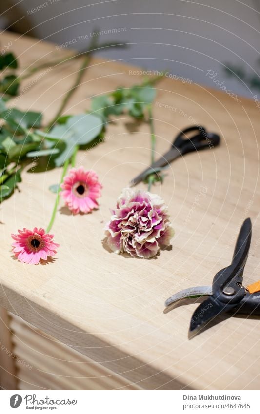 Florist shop - a workplace table for a florist artist with flowers and tools for creating bouquet arranging compose rustic composition romantic workshop