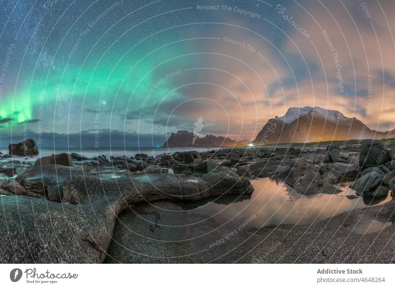 Bright northern lights over North Sea polar night sea bright rocky coast nature landscape colorful arctic island seashore aurora borealis phenomenon cold