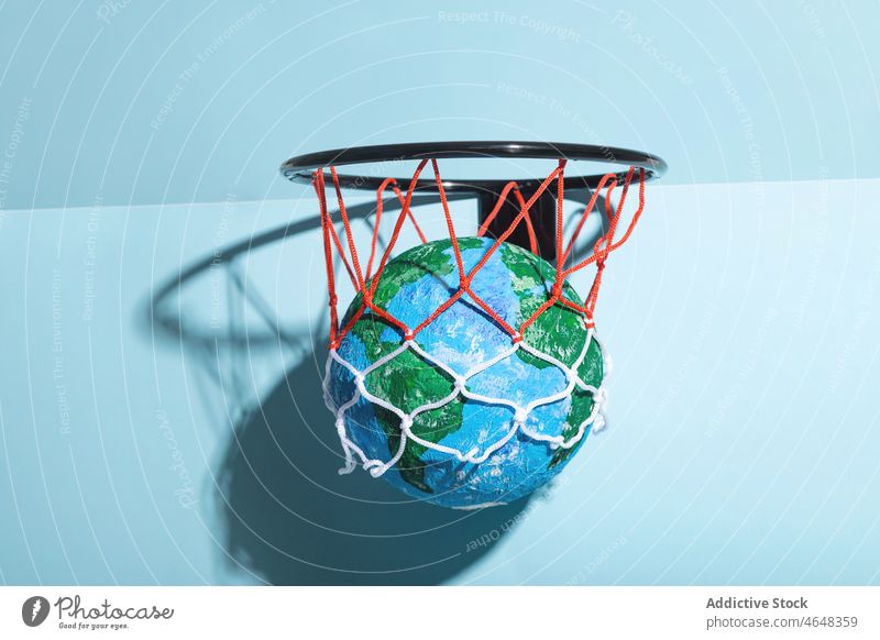 Small Earth ball in basketball hoop earth planet globe catch concept global save protect geography environment round color shadow world form sphere colorful