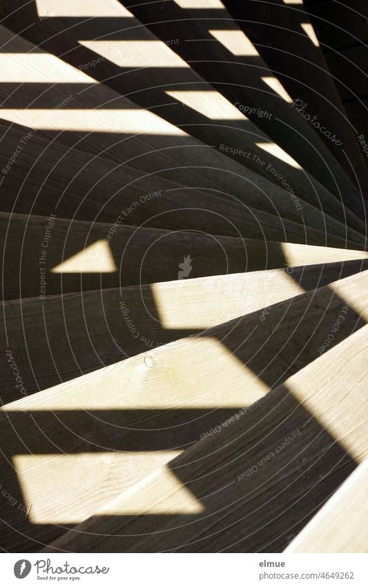 Shadows of the wooden structure fall on the spiral staircase and form a pattern / shadow play Winding staircase wooden staircase Wood construction Shadow play