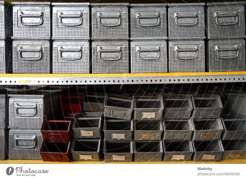 Old steel shelf with boxes and boxes for small parts in an old factory hall in the district of Margaretenhütte in Giessen on the Lahn River in Hesse, Germany