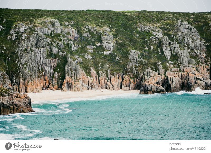 a small lonely beach bordered by rocks on a steep coast Beach Loneliness Water Rock Ocean Summer Tourism seclusion Undiscovered Difficult to access Waves