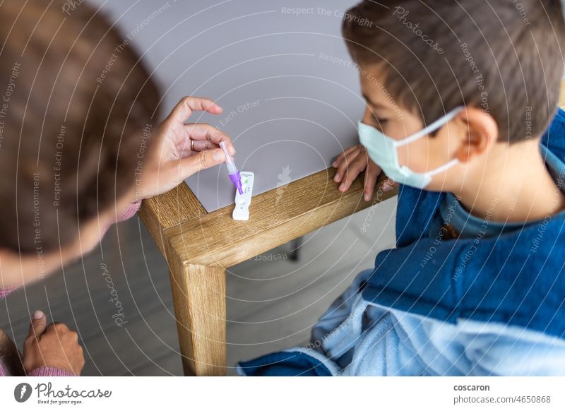 Mother doing an antigen test to her son at home 2019-ncov analysis boy care check child corona coronavirus covid covid-19 covid19 diagnostic disease education