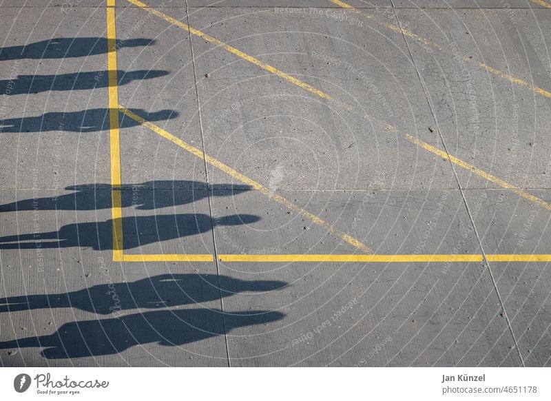 Shadow of several people on asphalt floor Crowd of people sieving Shadow play shadow cast silhouette Sunlight Ground Asphalt road Gray Yellow Stripe Geometry