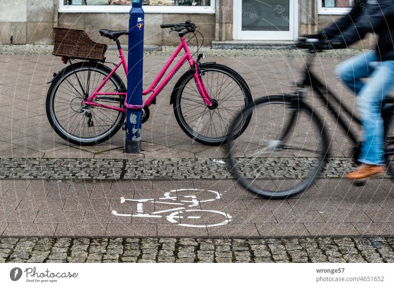 Bike lane with cyclist and bike secured to lamppost in city 1/2 Cycle path Shandy Town safeguarded Associated Bicycle Transport Cycling Road traffic Mobility