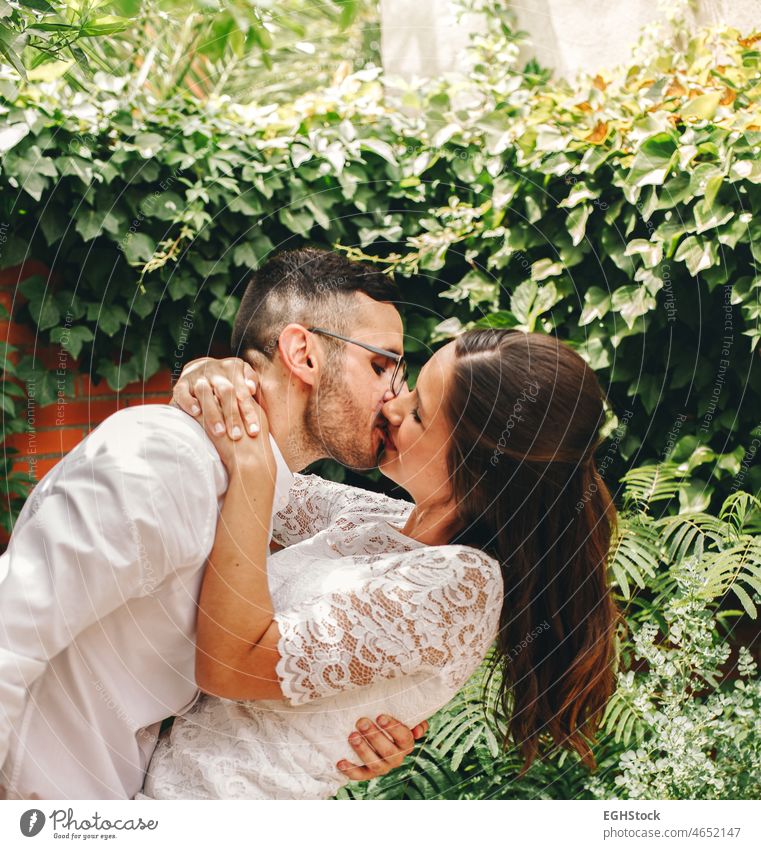 Newlywed couple kissing and dancing on their wedding day. Wife wears a beautiful lace wedding garter.Union and love concept. hugging satin newlywed caressing