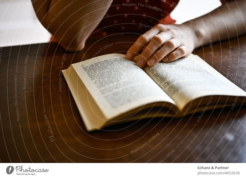 Woman sitting at table reading a book Reading Table Book Novel Literature Sit free time Reading matter books Academic studies Library