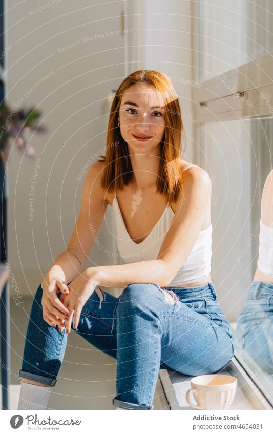 Young woman sitting near window and looking away reflection appearance dreamy rest wistful pensive home female young bare shoulders relax ponder alone top