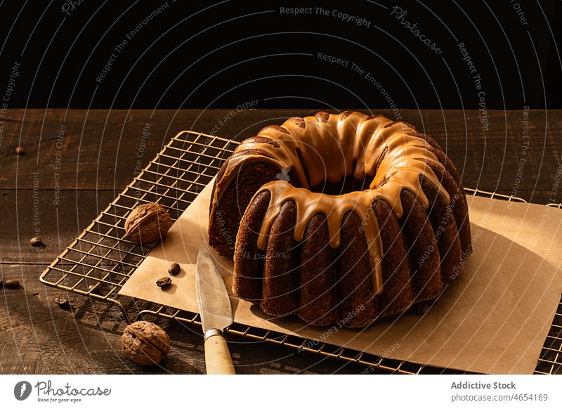 Coffee walnut bundt cake on rustic wooden table treat festive sponge brown background winter cuisine cooking knife wooden background walnuts glazed yogurt