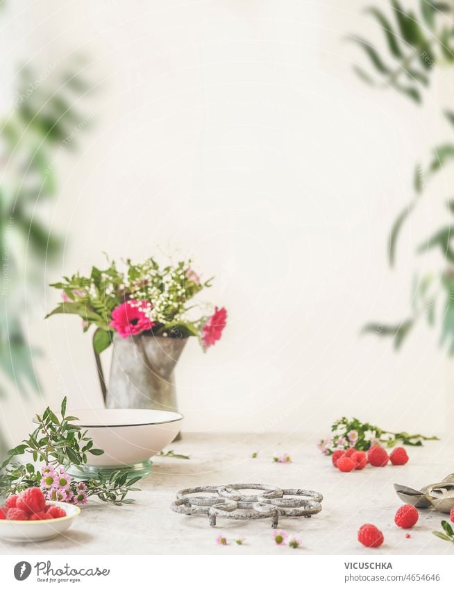 Kitchen product display at white wall background. Empty space for your design. kitchen raspberries flower bouquet branches empty front view copy space