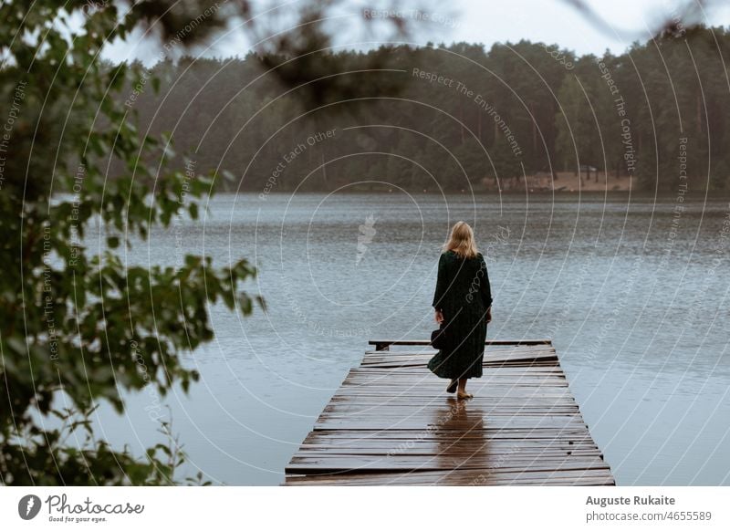 Woman walking on a bridge near the lake on a rainy day Rain Wet Rain jacket Water Bad weather Weather Autumn Drops of water Nature raindrops Gray Detail