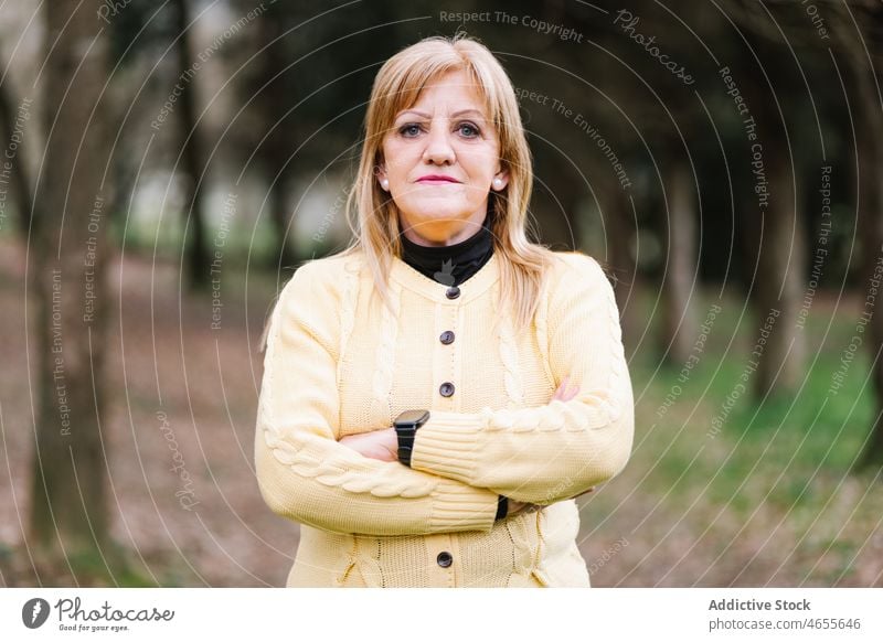 Calm woman standing in park middle age portrait calm casual mature appearance confident greenery lifestyle garden individuality complexion human face