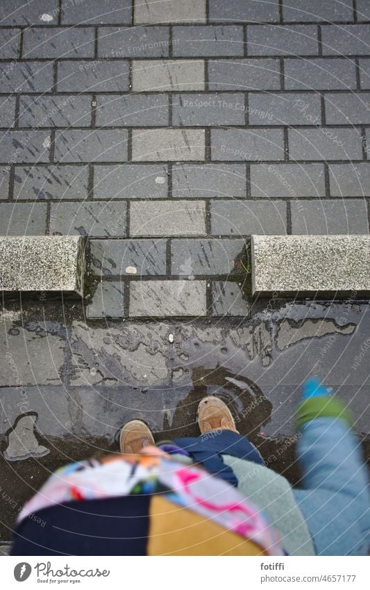 Child jumps into a puddle from a bird's eye view Splash of water Inject Exterior shot fun Water Wet Playing Infancy Paving stone Toddler Happiness Joy