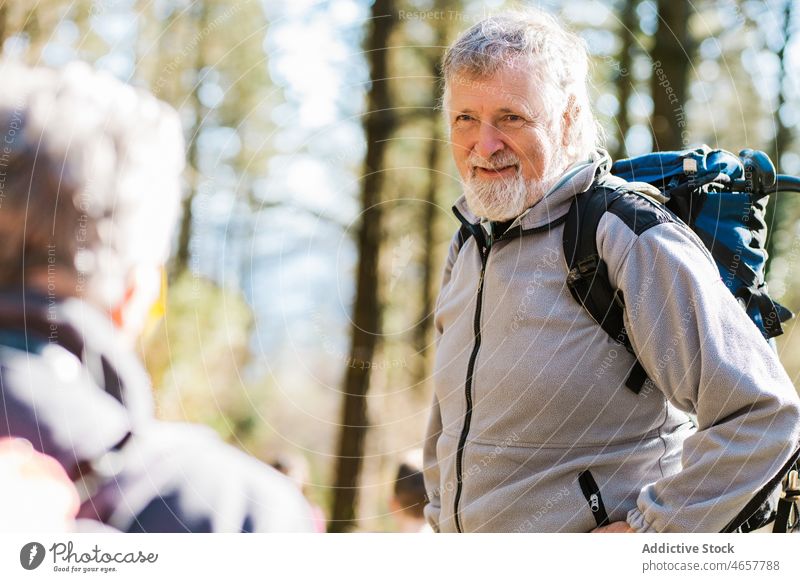 Elderly travelers with backpacks in forest hiker together senior trekking autumn friend woods activity fall explore adventure elderly backpacker trip daytime