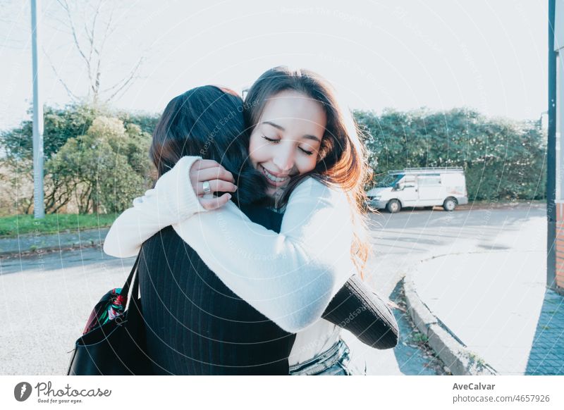 Cheerful friendly mixed race students embrace, after a long time splitted. Happy attitude. Return to class after having holiday outside the campus with copy space aside for your advertisement