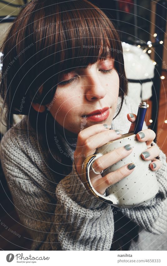 Young and dreamy woman enjoying a cup of coffee home warm tea winter autumn mood moody portrait comfort quiet tranquility life lifestyle comfy cute brunette