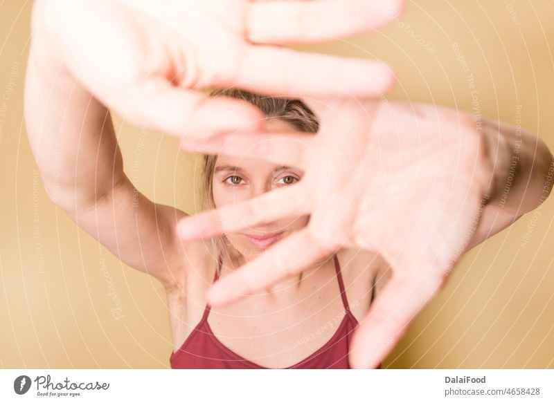 woman covering herself with her hands summer yellow background horizontal