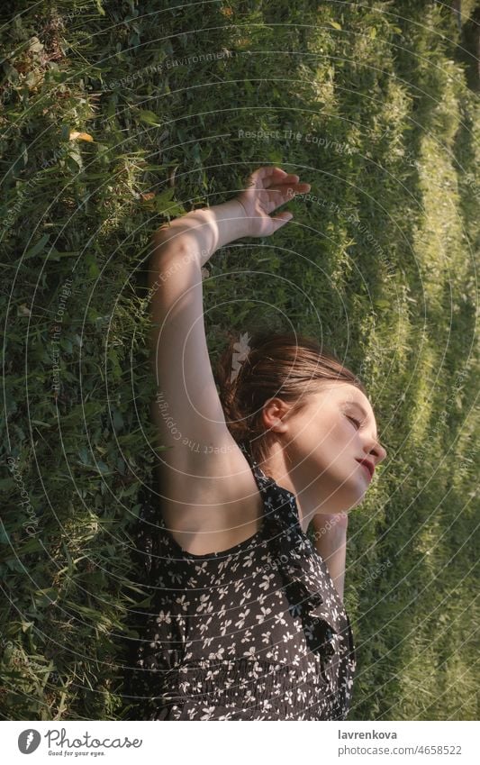 Young woman in black dress lying on green grass caucasian portrait meadow nature above adult daydreaming female garden girl hands happy leisure lifestyle