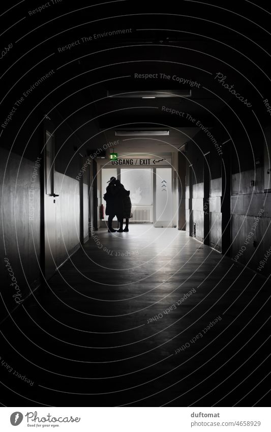 Couple standing at the end of a dark hallway hugging each other Hallway Love Grief Corridor Contrast Light Dark door Shadow Interior shot Architecture Building