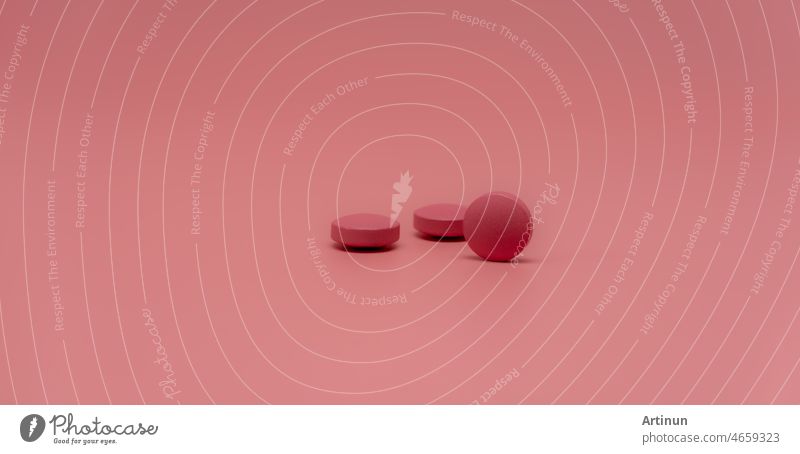 Selective focus on round pink tablet pill on pink background. Pharmacy horizontal web banner. Pharmaceutical industry. Prescription drug. World Health Day background. Vitamins and minerals concept.