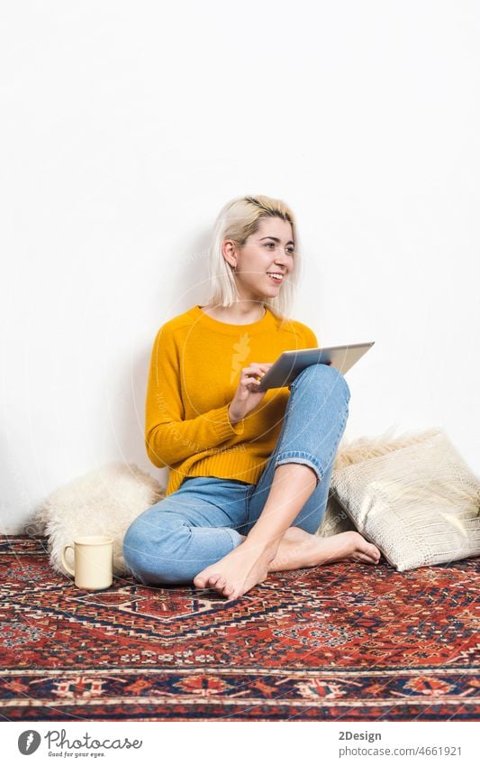 Woman at living room using her tablet person sitting technology lifestyle indoor woman adult reading young adult communication computer female cyberspace floor