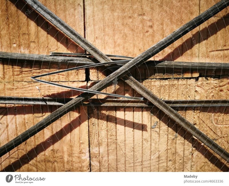 Brown crossed wooden slats in front of light brown wooden shed in summer sunshine in Adapazari, Sakarya province, Turkey Wood shack wooden crate Stick