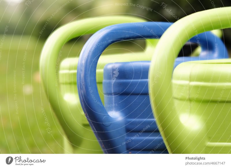 Three watering cans in green and blue against blurred background Watering can Cast Green Blue handles Door handle Gardening Exterior shot Gardener Jug Summer