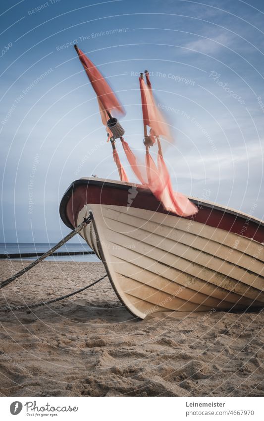 Fishing boat with red fishing net marker flags on Usedom beach Ocean Baltic Sea Sand Koserow Wind Fisherman connected Anchor bow Keel