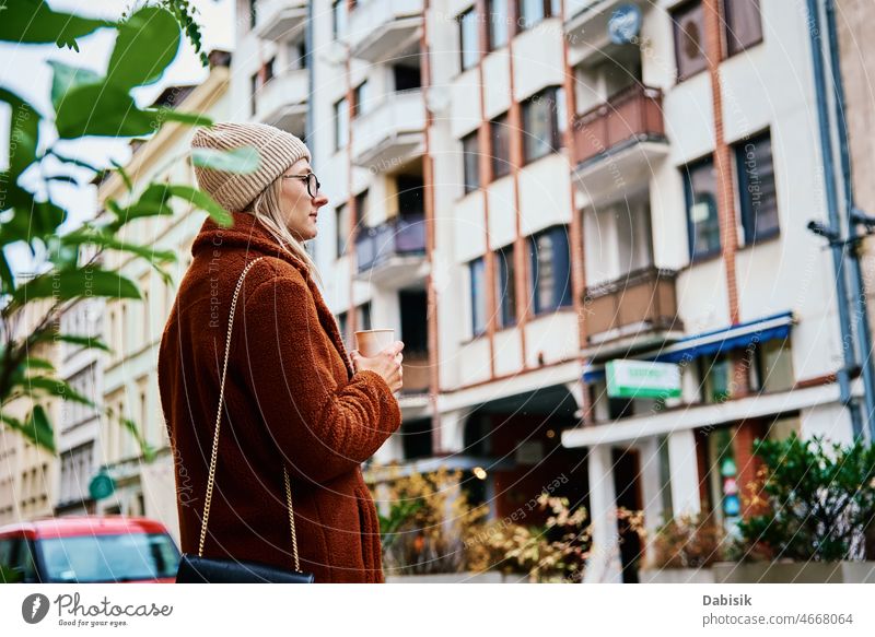 Woman at city street with coffee cup woman walking lifestyle eyeglasses urban crosswalk drink fashion business takeaway city life girl model road casual lady