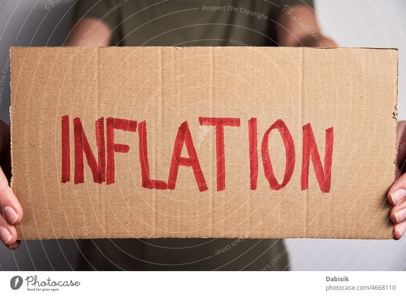 World inflation concept. Woman hold sheet with word inflation crisis finance economic risk consumer high currency us europe business dollar money wealth growth