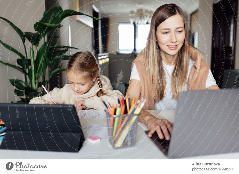 Caucasian family working and studying online at home and using laptop. Distance or remote learning for child. Pretty stylish schoolgirl studying homework math during coronavirus covid-19 quarantine and social distancing