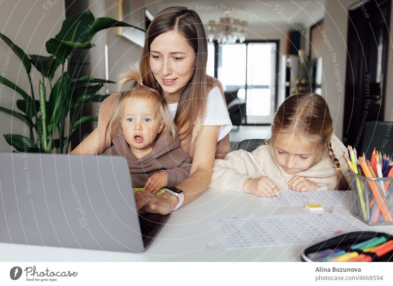 Caucasian family working and studying online at home and using laptop. Distance or remote learning for child. Pretty stylish schoolgirl studying homework math during coronavirus covid-19 quarantine and social distancing