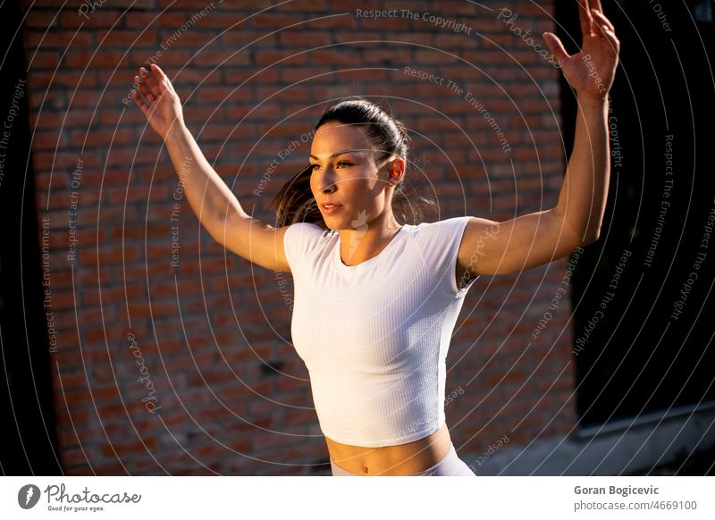 Young woman stretching during training in the urban environment active activity adult athlete attractive body break brunette caucasian city clothes day exercise