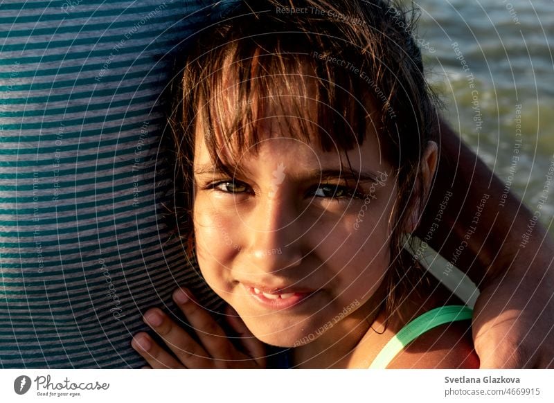 Portrait of a tanned smiling toddler girl on the beach in summer sunset child cute happy holiday kid sea smile travel vacation young beautiful beauty caucasian