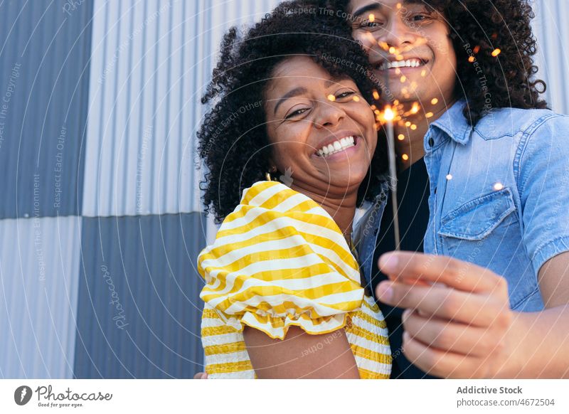 Happy ethnic couple hugging and burning Bengal light sparkler love joy festive embrace romantic happy occasion boyfriend girlfriend enjoy together bengal close