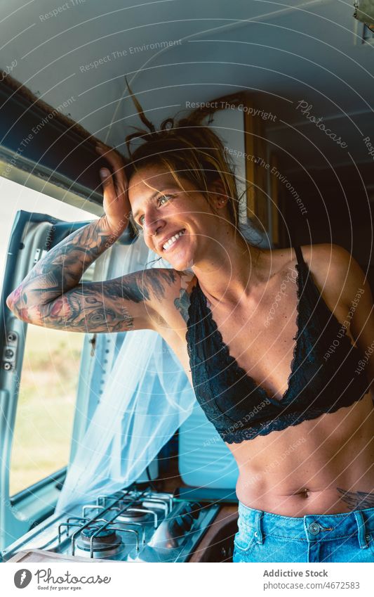 Smiling woman in bra looking at window in camper van traveler happy admire trip rv enjoy caravan female trailer positive tourism explore tourist carefree