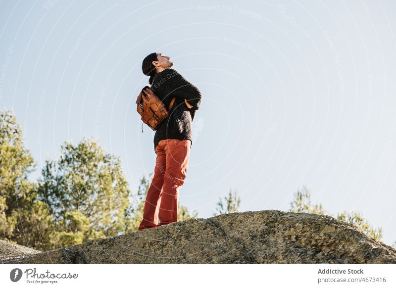 Traveling man standing on cliff tourist traveler sky vacation journey trip hike top male formation contemplate nature rocky adventure reach achieve tourism