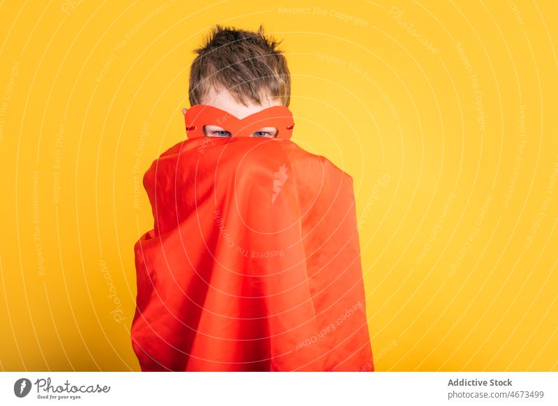 Boy in superhero mask and cape covering face boy child costume appearance cover face hide portrait studio power kid courage confident brave strong personality