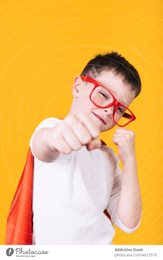 Playful boy in superhero uniform Playful boy in superhero uniform reaching out fist towards camera child flight fly clench fist costume portrait studio power