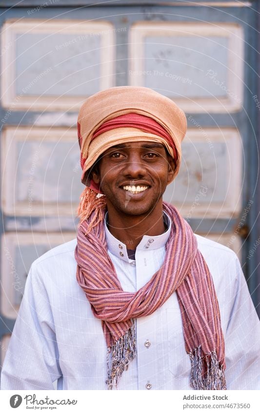 Optimistic Arab man in turban on sunny day in city smile portrait tradition headwear local authentic glad toothy smile male black ethnic arab egyptian optimist